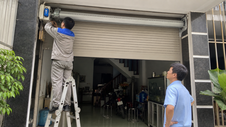 Kỹ thuật viên kiểm tra motor cửa cuốn tại nhà phố