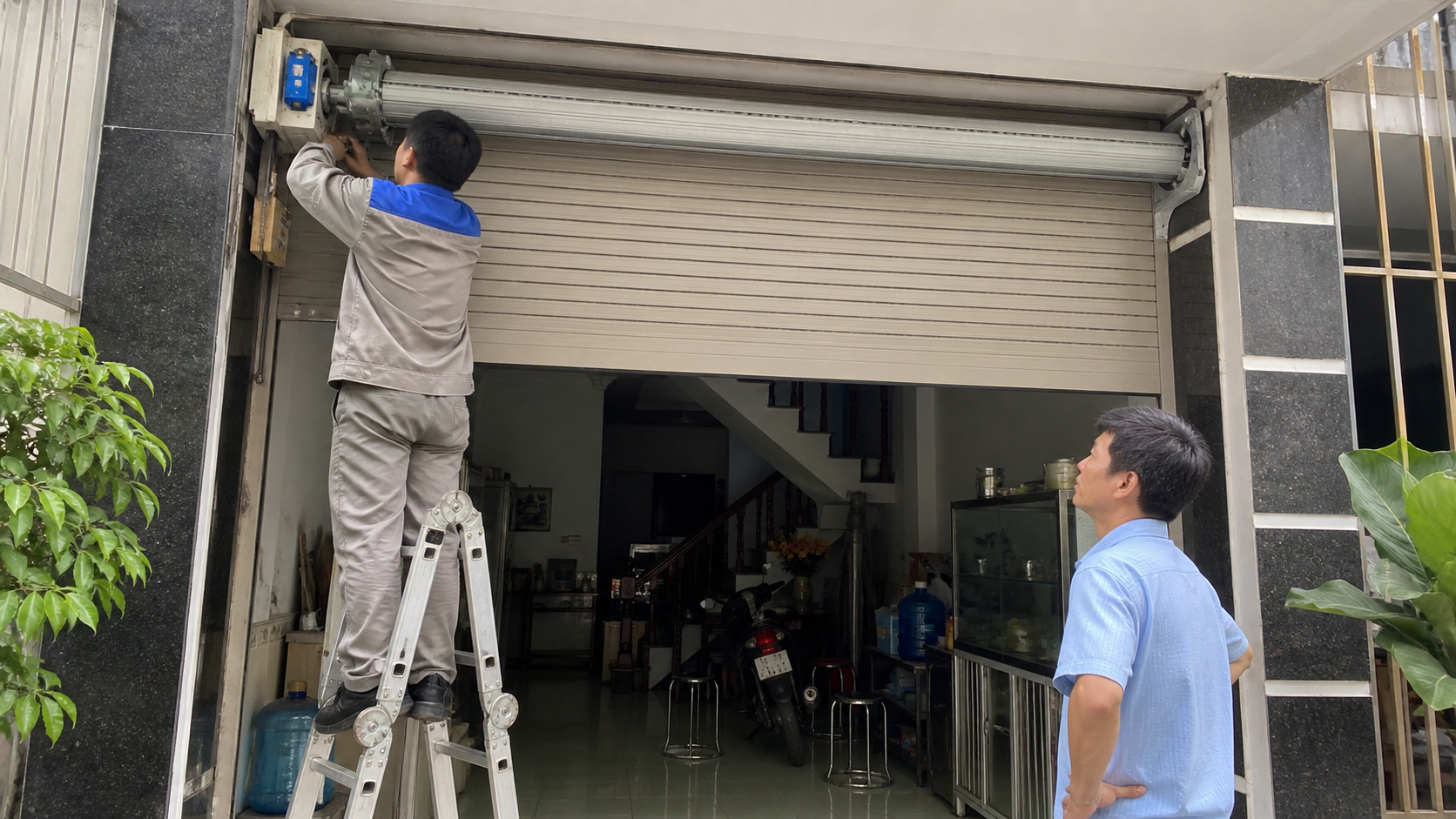 Kỹ thuật viên kiểm tra motor cửa cuốn tại nhà phố